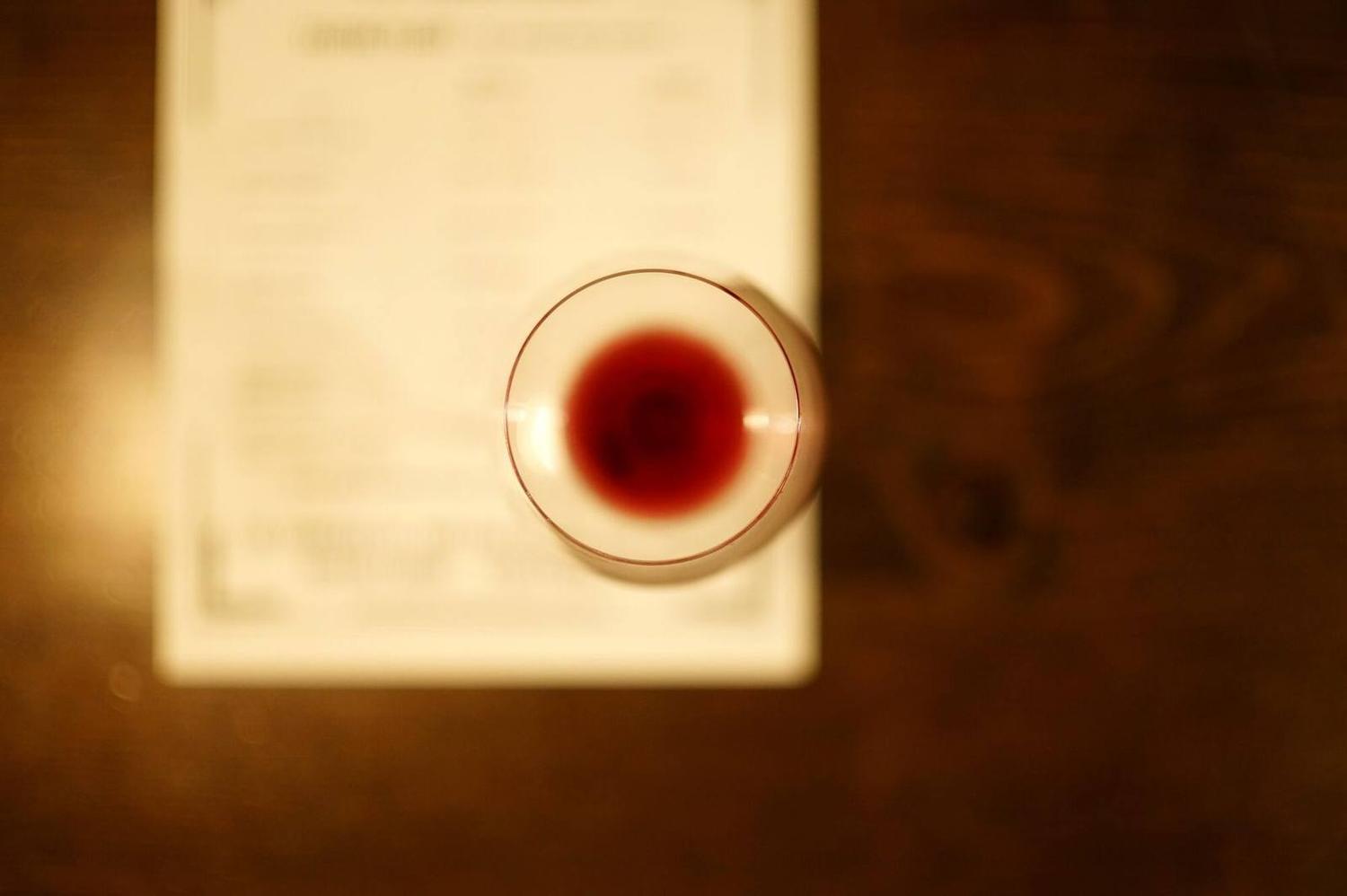 A glass of red on a bar top